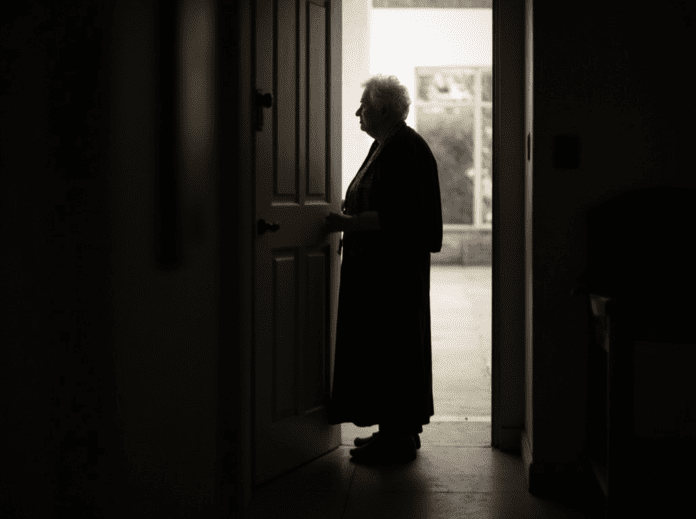 an-elderly-woman-waiting-by-the-door-s5b4p